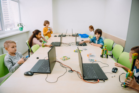group of serious kids working with computers on machinery classの写真素材