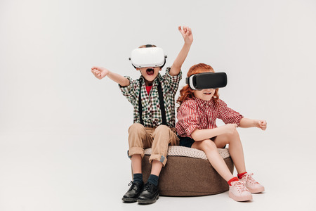 adorable little children playing in virtual reality headsets isolated on greyの写真素材