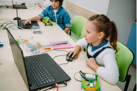 little girl programming her diy robot with laptop, stem education conceptの写真素材