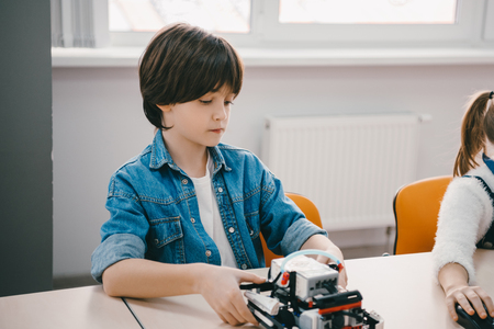 serious little kid making diy robot, stem education concept