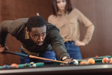 african american man playing in pool at bar