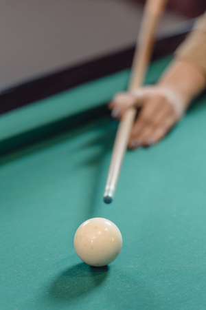 cropped image of hand with cue over pool tableの写真素材