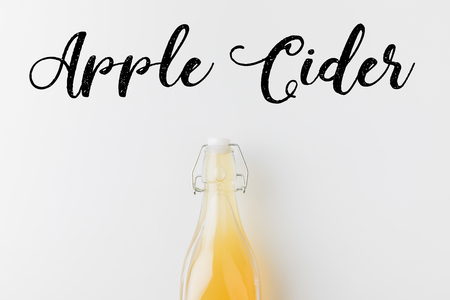 bottle of apple cider with hand written lettering on white surfaceの写真素材