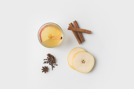 top view of apple cider composition with spices and pear slices on white tabletopの写真素材