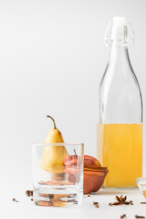 delicious cider in bottle with glass and fruits on white surfaceの写真素材