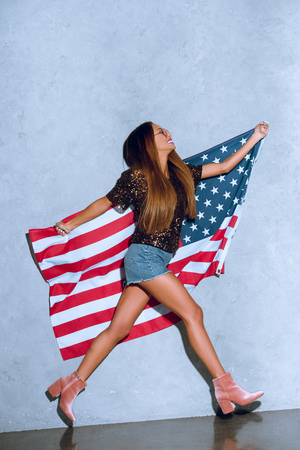 happy african american woman with american flag in handsの写真素材