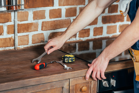 cropped shot of male hands and tools on wooden surfaceの写真素材