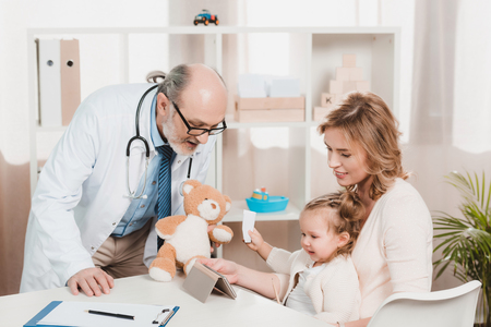 mother and little daughter at doctors reception in clinicの写真素材