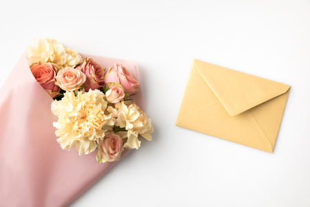 beautiful pink roses in paper wrap with envelope isolated on whiteの写真素材