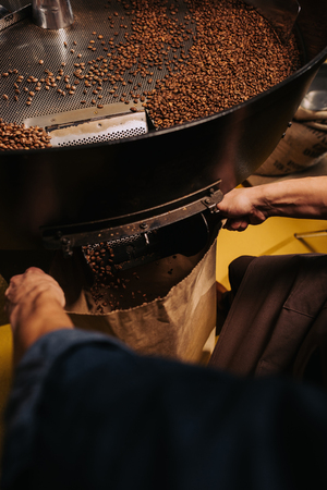 partial view of coffee roaster working on roasting machineの写真素材