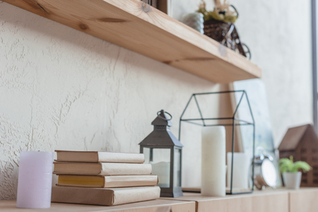 close-up shot of bookshelf with beautiful decorations and stack of booksの写真素材