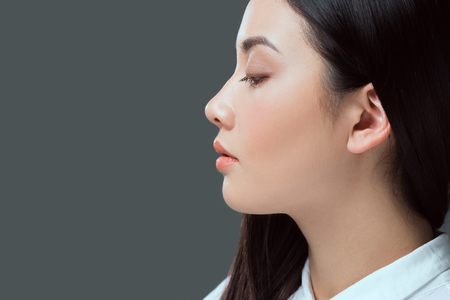 profile portrait of beautiful young asian woman looking away isolated on greyの写真素材