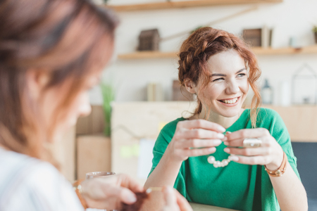 smiling young women making accessories at workshopの写真素材