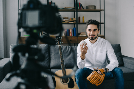 sport blogger recording new video about baseball and holding ball and mittの写真素材