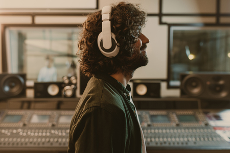 side view of sound producer in headphones enjoying music at studioの写真素材