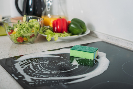 cleaning sponge and soap on kitchen stoveの写真素材