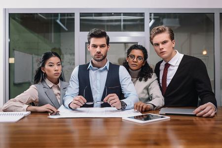 multicultural businesspeople with digital devices and paperwork in officeの写真素材