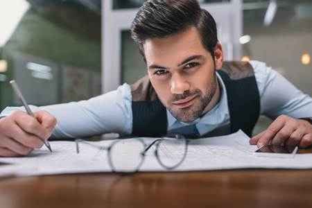 adult businessman working with blueprint in officeの写真素材