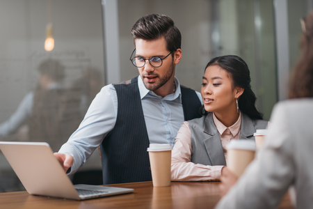 adult multiethnic businesspeople working with laptop in officeの写真素材