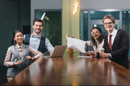 multicultural business team working with documents and laptop in office