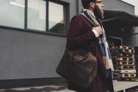 young bearded man in stylish clothing with leather bagの写真素材