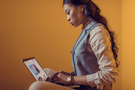 asian businesswoman using laptop with ebay website in front of orange wallのeditorial素材