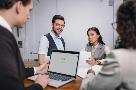 multiethnic business team with documents and laptop with google websiteのeditorial素材