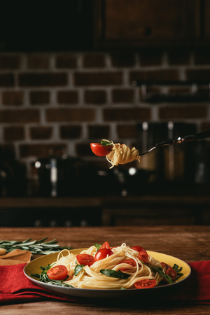 traditional italian pasta with tomatoes and arugula on forkの写真素材