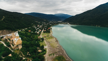aerial view of city and church in beautiful georgian mountains with river