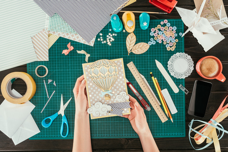 cropped image of woman holding scrapbooking postcard with wooden balloonの写真素材