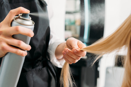cropped image of hairdresser applying hair sprayの写真素材