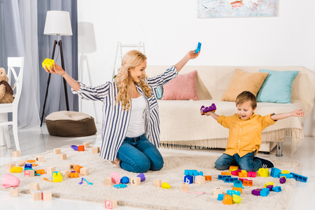 happy mother and son playing with colorful blocks at homeの写真素材