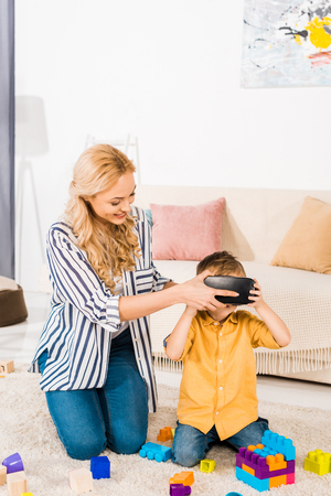 beautiful mother with adorable little son using virtual reality headset at homeの写真素材