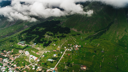 aerial view of city in green mountains with clouds, Georgiaの写真素材