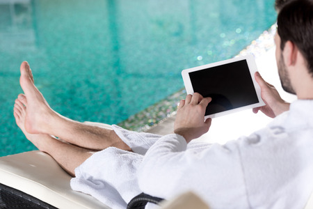 cropped shot of man in bathrobe using digital tablet with blank screenの写真素材
