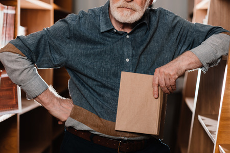 cropped image of grey hair librarian holding bookの写真素材