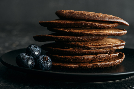 close-up shot of stack of chocolate pancakes with blueberriesの写真素材