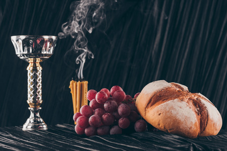 bread, grapes, candles and chalice on dark fabric for Holy Communionの写真素材