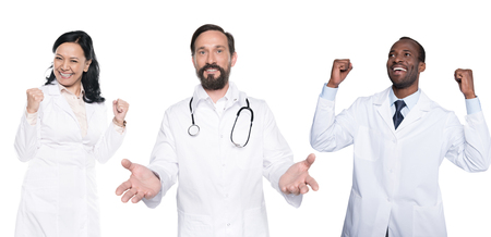 portrait of happy multicultural doctors in white coats isolated on whiteの写真素材