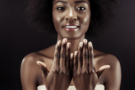 beautiful african american woman showing her nails isolated on blackの写真素材