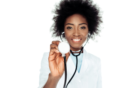 smiling female doctor looking at camera with stethoscope isolated on whiteの写真素材