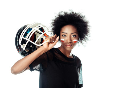attractive female american football player with painted face holding helmet isolated on whiteの写真素材
