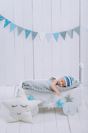 innocent little infant baby lying in wooden baby cotの写真素材