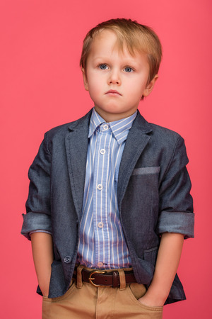 portrait of adorable little boy isolated on pinkの写真素材