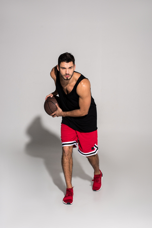 handsome young basketball player running with ballの写真素材