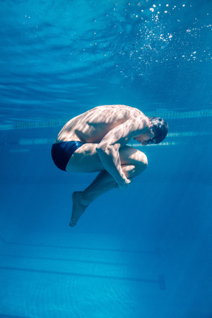 underwater picture of male swimmer in cap and gogglesの写真素材
