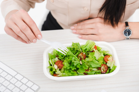 overhead view of businesswoman with take away food at workplace in officeの写真素材