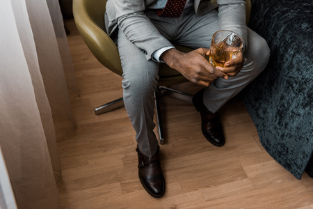 cropped view of african american man holding glass of whiskeyの写真素材