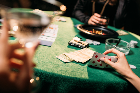cropped image of women playing poker together at table in casinoの写真素材