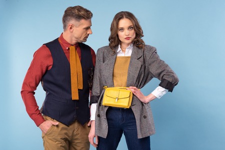 beautiful fashionable couple in formal wear posing isolated on blueの写真素材